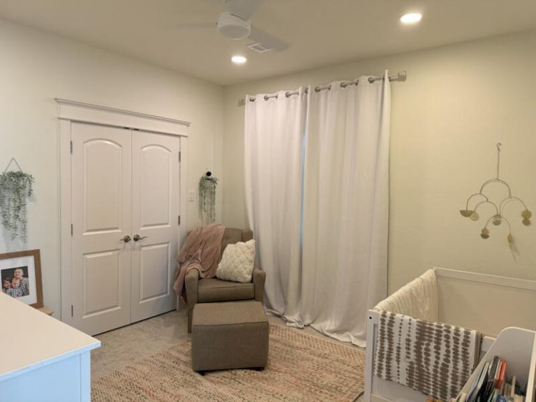 Completed nursery with crib, upholstered glider chair, ceiling fan and double closet doors - second story addition in Houston, TX