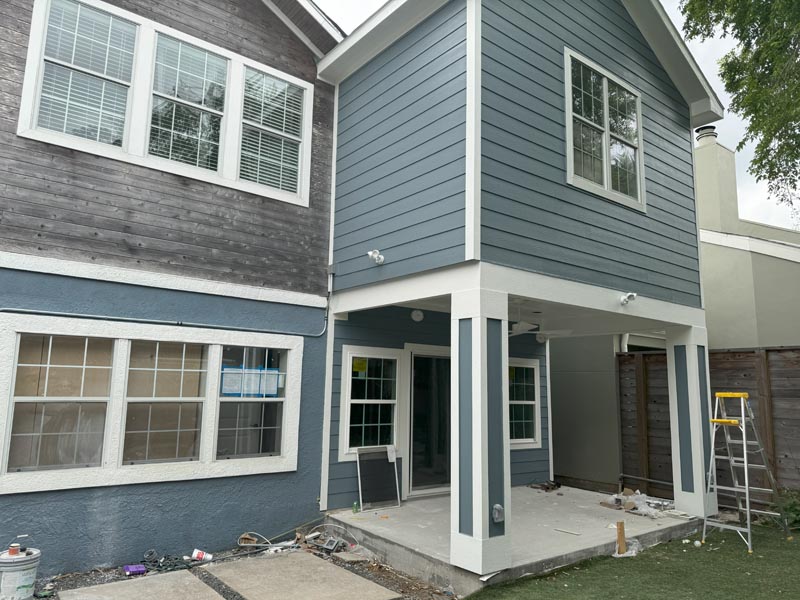 Two-story Houston home with completed second story addition showing blue and gray siding