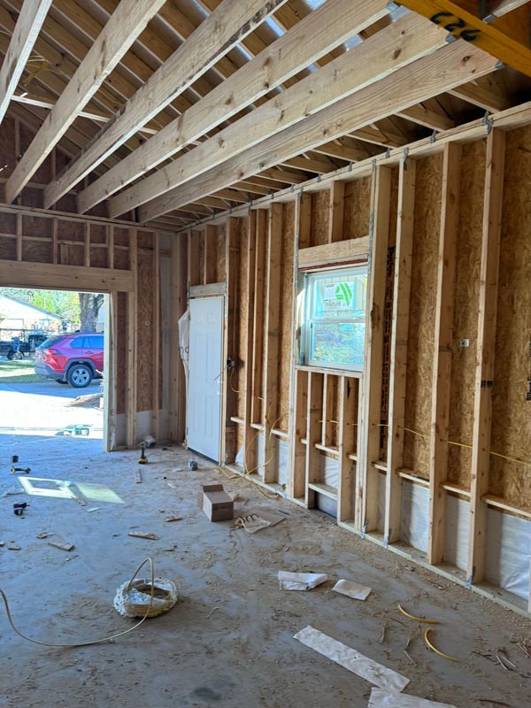 Interior wall framing with studs and window openings during garage construction phase