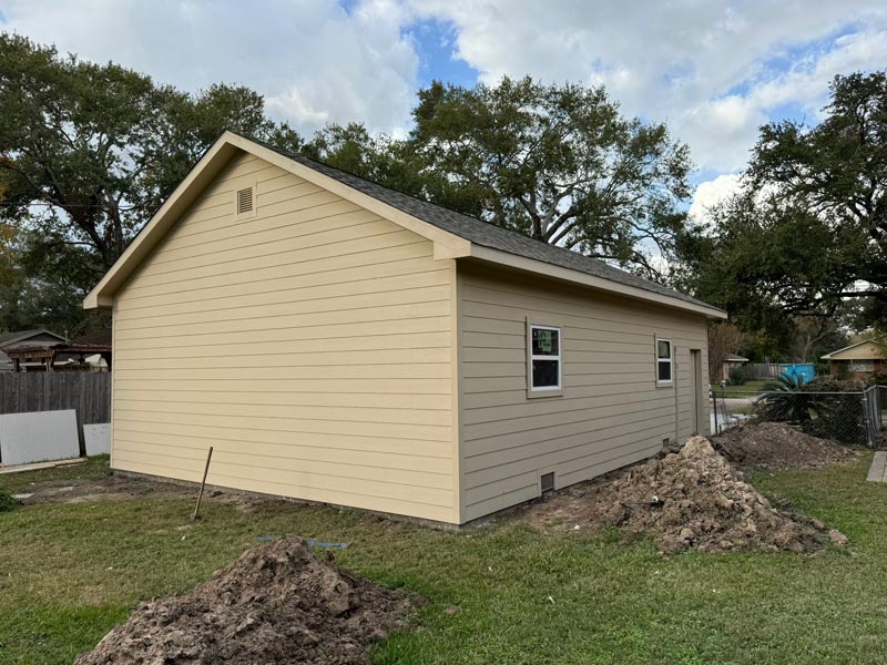 Completed garage exterior showing beige siding and dual side windows in Houston