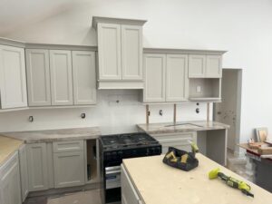 Licensed contractors installing custom kitchen cabinets in Harris County home renovation project