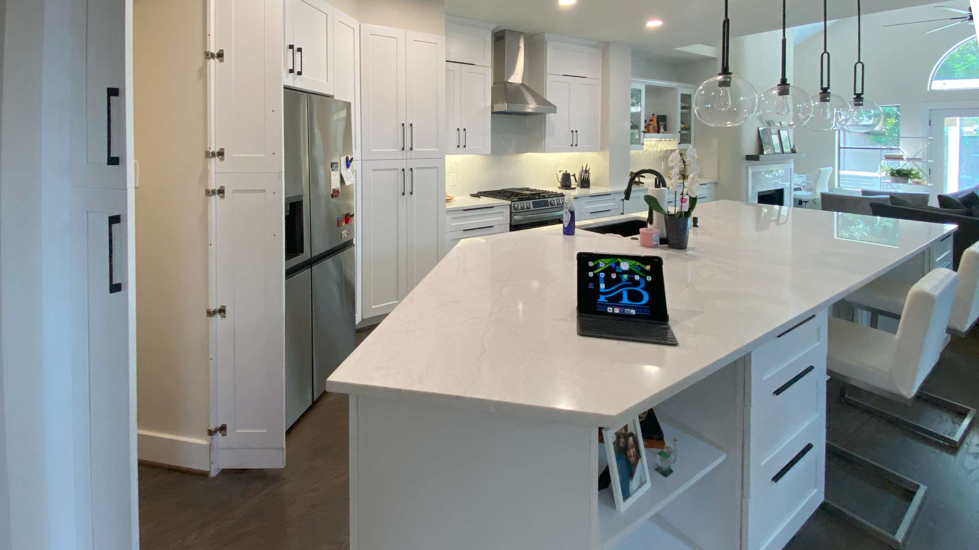Modern kitchen remodel with white cabinets, quartz island and pendant lighting in Houston, TX.