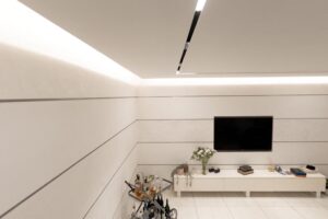 White media wall with integrated storage and flat-screen TV in Houston living room renovation