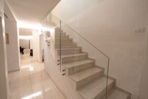 Modern floating staircase with glass railing and LED lighting in Houston home renovation