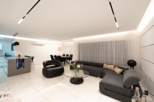 Contemporary living room with black modular sectional sofa and curved accent chair in Houston remodel