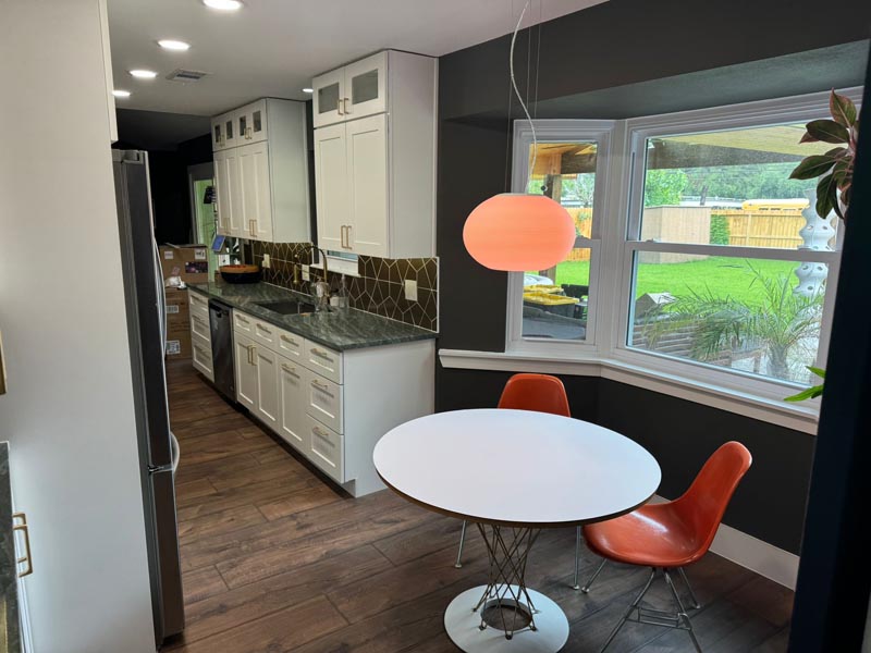 Complete galley kitchen remodel Houston showing white cabinets luxury vinyl plank flooring