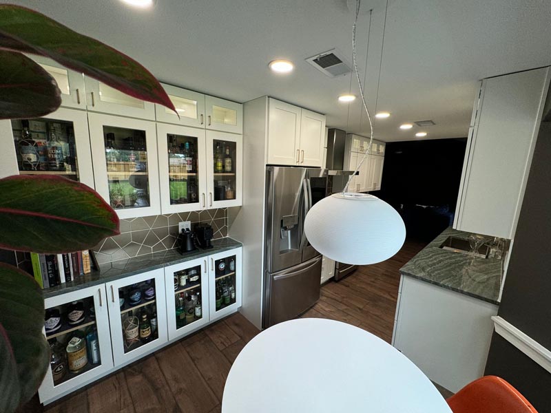 Budget kitchen remodel Houston with custom display cabinets modern lighting and efficient galley layout