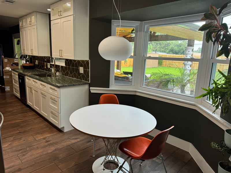 affordable kitchen transformation Houston TX showing breakfast nook white cabinets and contemporary orange accent chairs