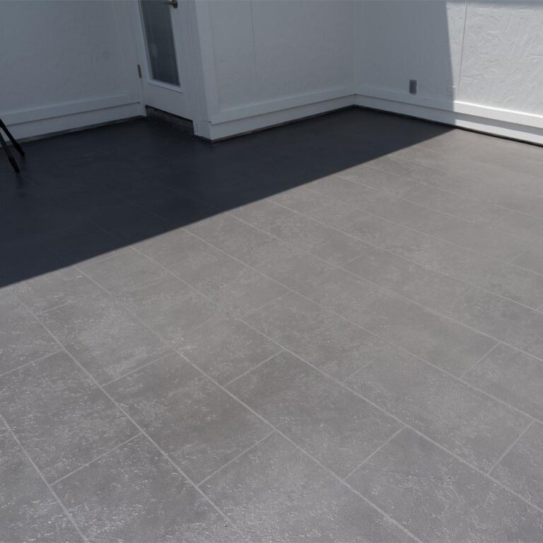 Completed two-tone gray tile-pattern waterproof decking at the balcony doorway, 77007 site