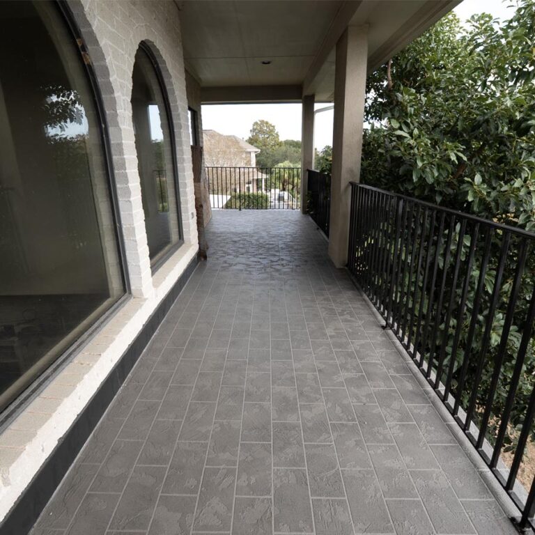 Long covered balcony walkway with completed stamped tile-pattern waterproof surface, 77586 site