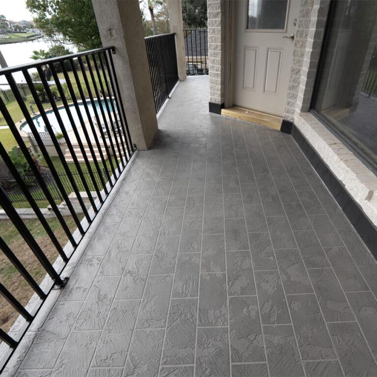 Restored second-floor balcony with stamped gray waterproof deck and iron railing overlooking the water, 77586 site