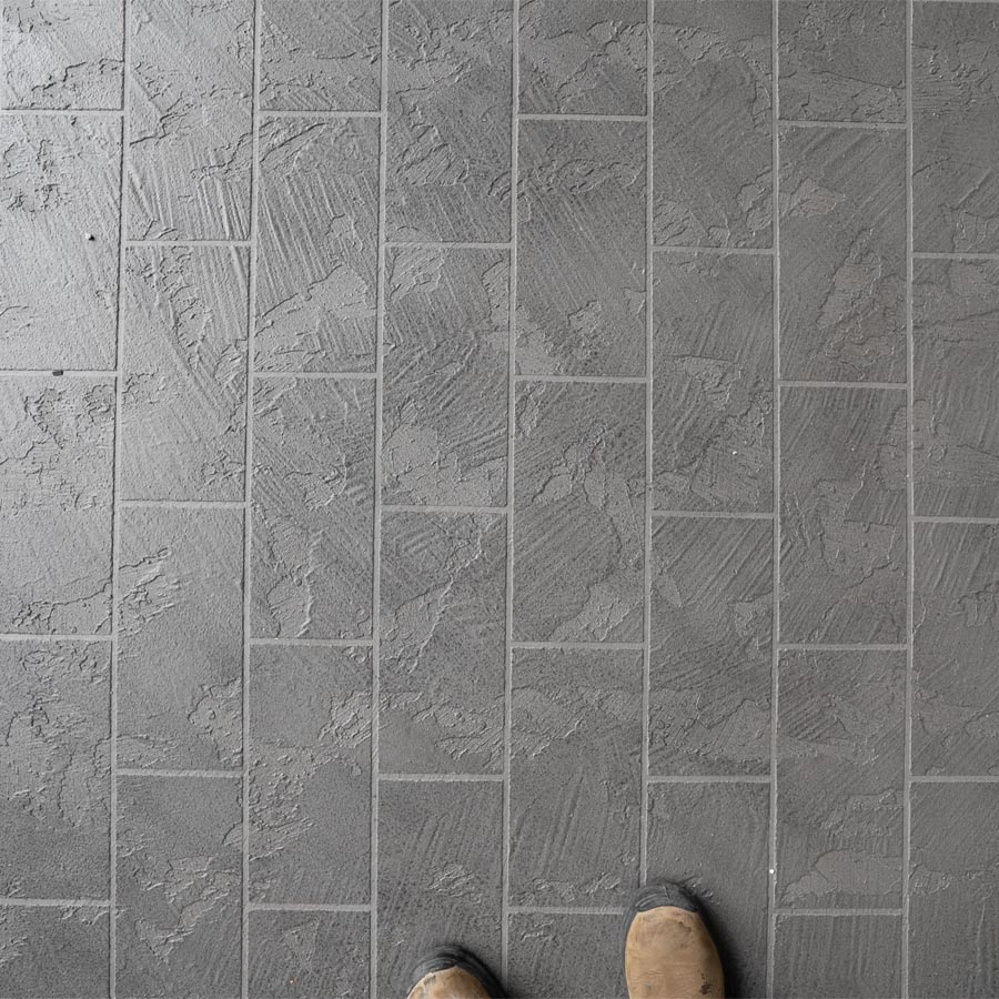 Top-down view of gray textured waterproof balcony coating with tile scoring in Seabrook, TX