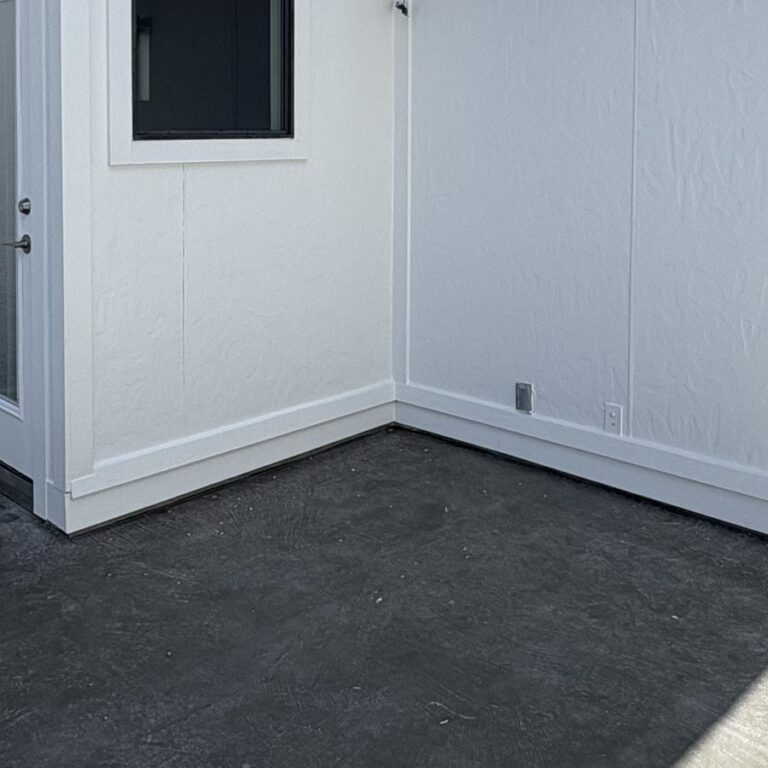 Balcony corner at patio door stripped to dark base coat after removal of old surface, 77007 site