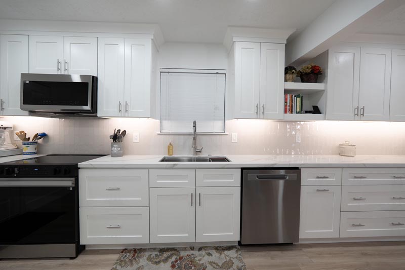Full kitchen remodel view with electric range dishwasher and white shaker cabinets Houston