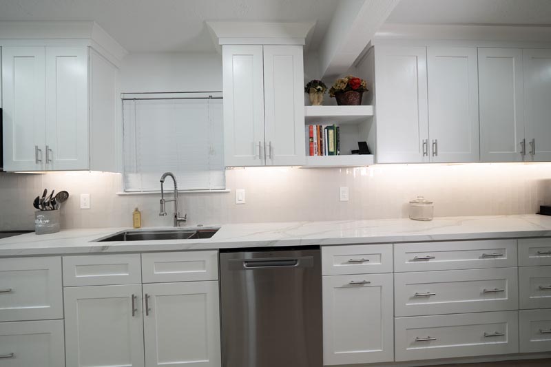 Kitchen countertop workspace with undermount sink white cabinets and open shelving display
