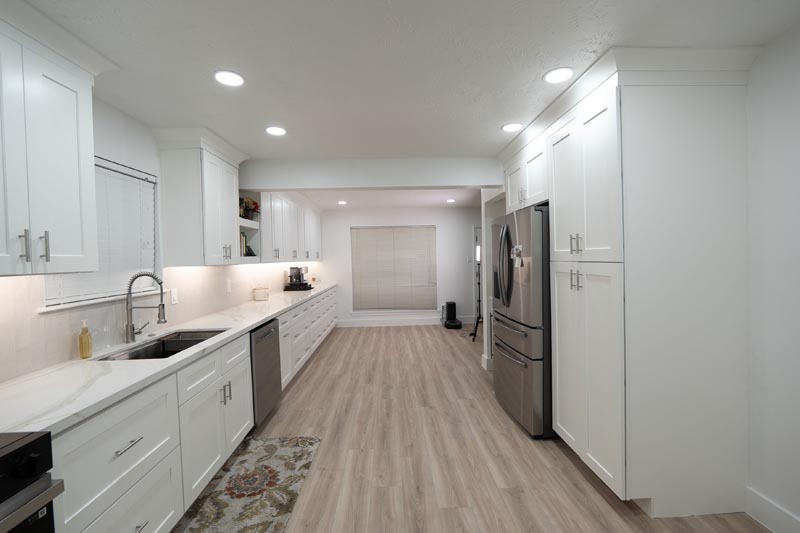 Complete galley kitchen remodel with white cabinets and stainless appliances in N Fallen Houston