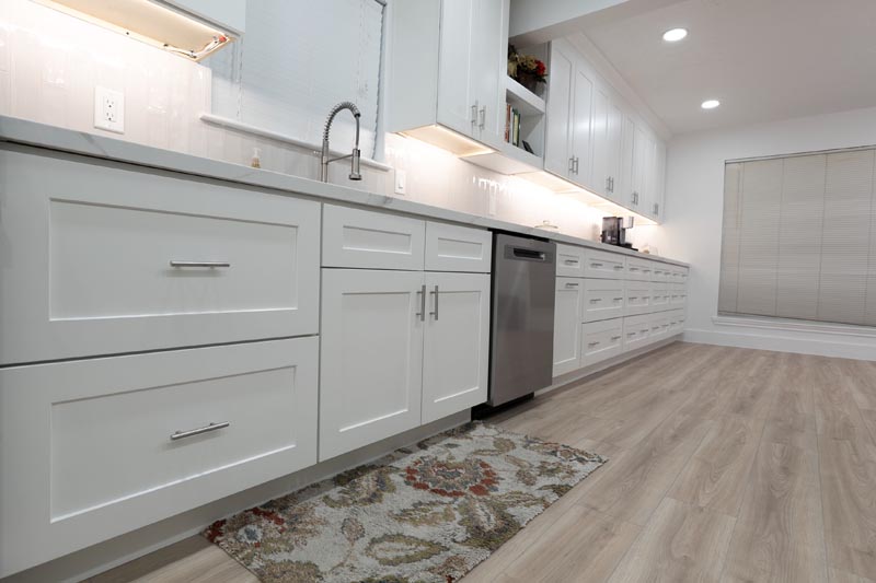 White shaker cabinet kitchen with luxury vinyl plank flooring and under-cabinet lighting Houston