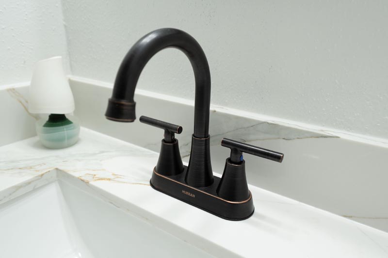 Oil-rubbed bronze bathroom faucet with white quartz countertop in Houston home remodel