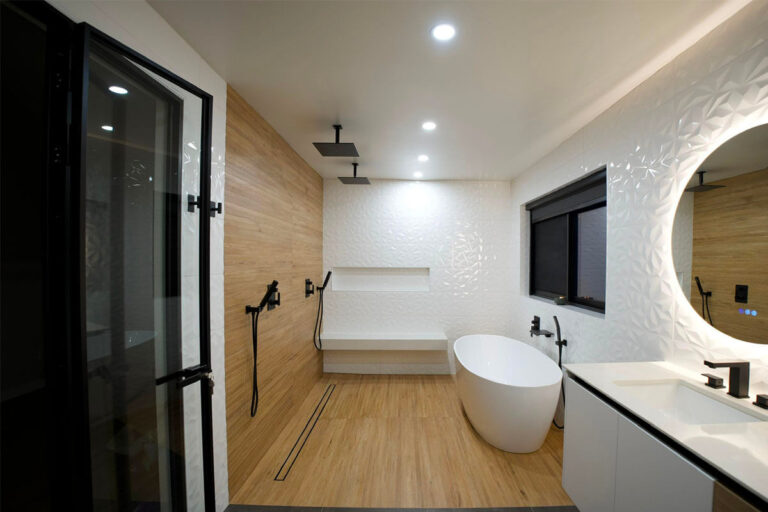 Finished spa bathroom with freestanding tub, wood-look tiled shower wall, dual ceiling rain showerheads and 3D textured white tile - condo